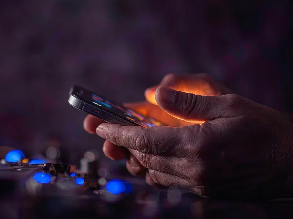 999JILI hands holding a smartphone in low light